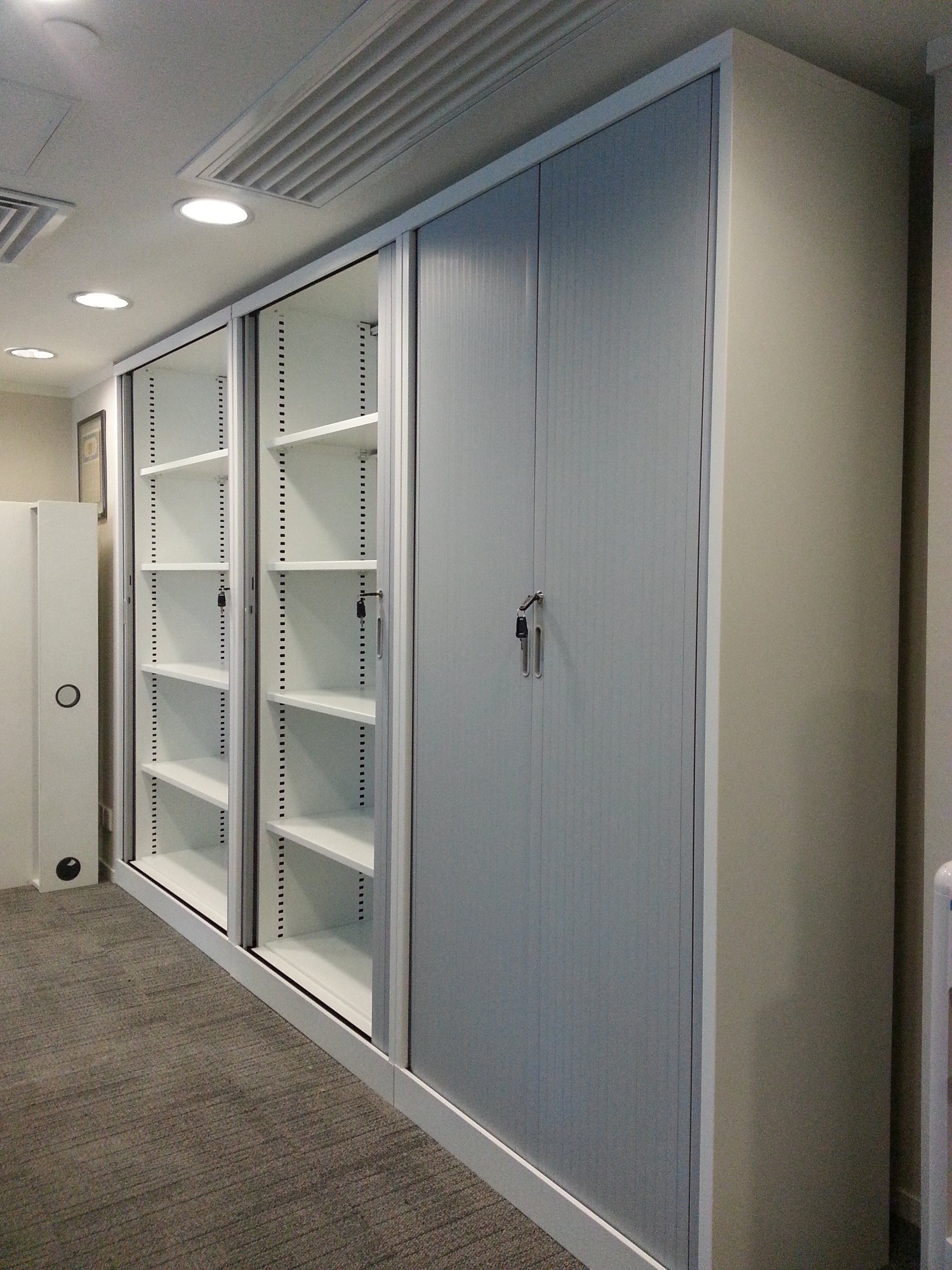 安裝於現代辦公室的鋼製捲門櫃,其順滑趟門設計節省走道空間,是理想的辦公室文件櫃 (office furniture)